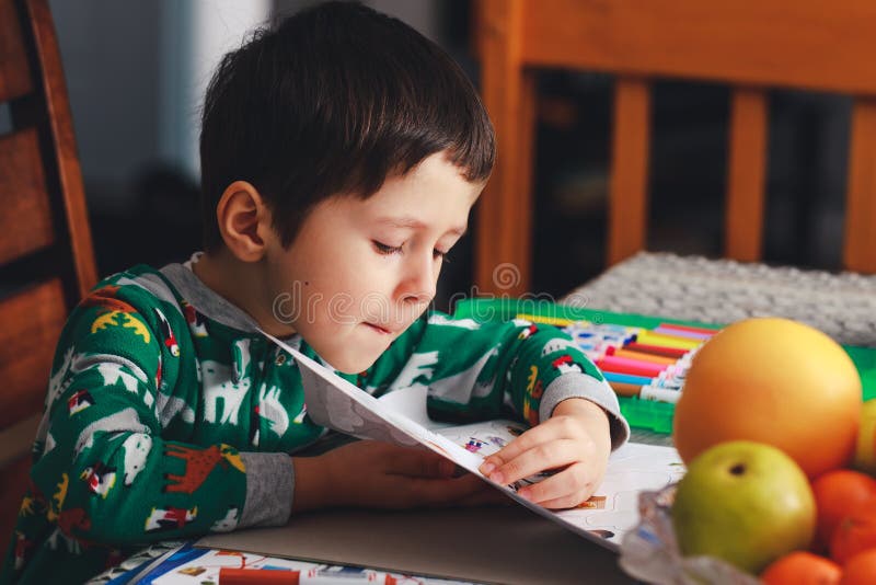 Aanbiddelijk opent weinig jongen pagina van oefenboek Leuke jongen readin stock foto Aanbiddelijk opent weinig jongen pagina van oefenboek Leuke jongen readin stock foto