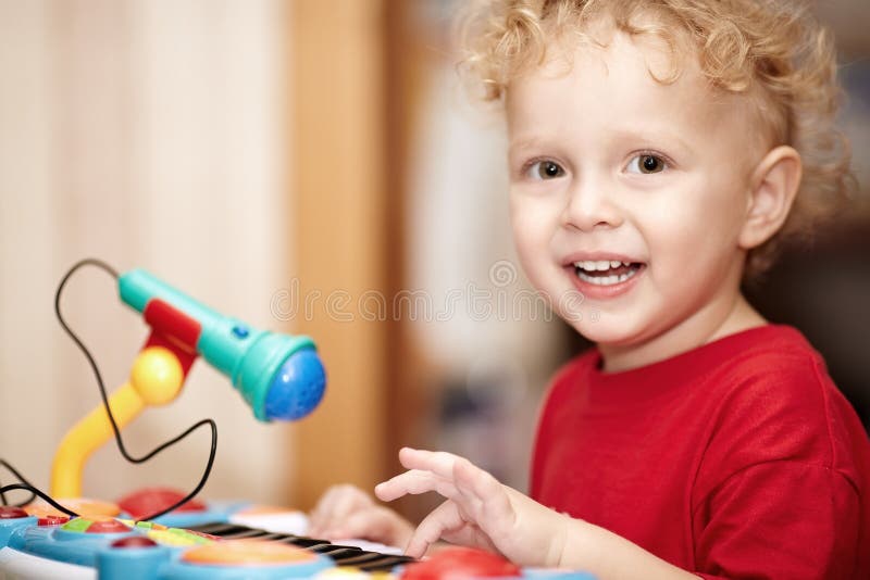 Aanbiddelijk weinig jongen die met een stuk speelgoed microfoon spelen