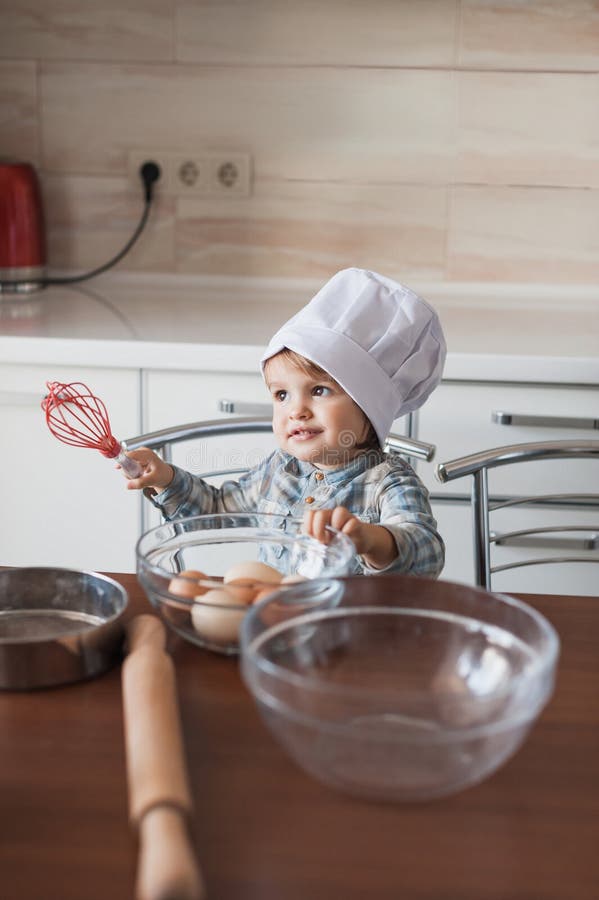 aanbiddelijk zwaait weinig jong geitje in de holding van de chef-kokhoed in hand klaar stock fotografie aanbiddelijk zwaait weinig jong geitje in de holding van de chef-kokhoed in hand klaar stock fotografie