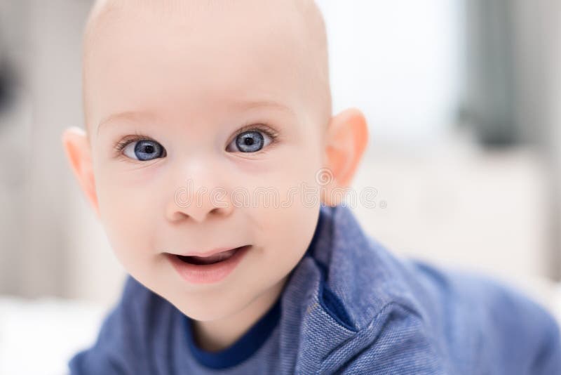 Aanbiddelijke babyjongen die met blauwe ogen direct camera bekijken die voor het proberen te bereiken Leuke peuter dichte omhoogg stock fotografie Aanbiddelijke babyjongen die met blauwe ogen direct camera bekijken die voor het proberen te bereiken Leuke peuter dichte omhoogg stock fotografie