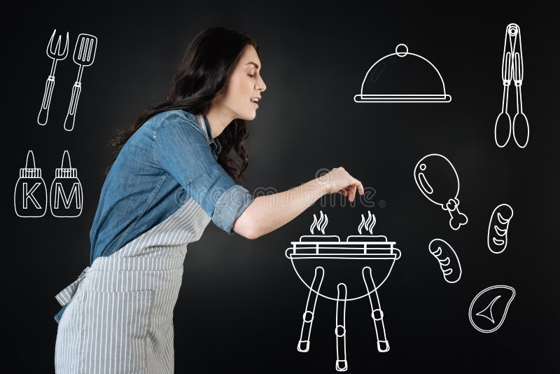 Aandachtige vrouw die zout toevoegen terwijl het maken van een barbecue royalty-vrije stock foto Aandachtige vrouw die zout toevoegen terwijl het maken van een barbecue royalty-vrije stock foto