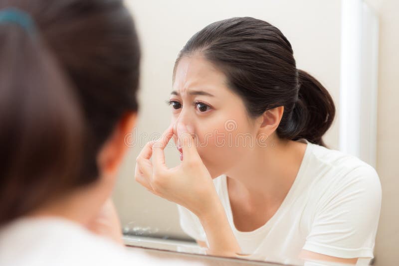Aantrekkelijke de holdingsneus gevonden acne van het schoonheidsmeisje royalty-vrije stock foto Aantrekkelijke de holdingsneus gevonden acne van het schoonheidsmeisje royalty-vrije stock foto