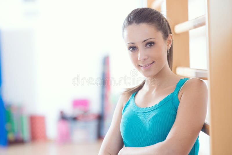 Aantrekkelijke glimlachende vrouw bij gymnastiek royalty-vrije stock foto Aantrekkelijke glimlachende vrouw bij gymnastiek royalty-vrije stock foto
