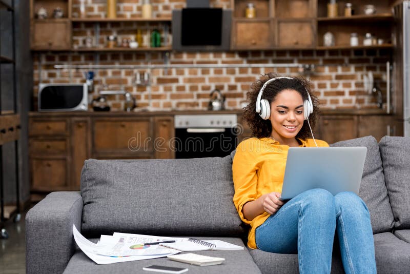 aantrekkelijke jonge vrouw die met laptop en het luisteren muziek werken royalty-vrije stock foto aantrekkelijke jonge vrouw die met laptop en het luisteren muziek werken royalty-vrije stock foto