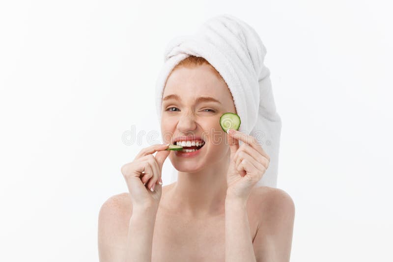 Attractive Young Woman with beautiful clean skin. White mask and cucumbers. Beauty treatments and cosmetology spa therapy. White background. Attractive Young Woman with beautiful clean skin. White mask and cucumbers. Beauty treatments and cosmetology spa therapy. White background.