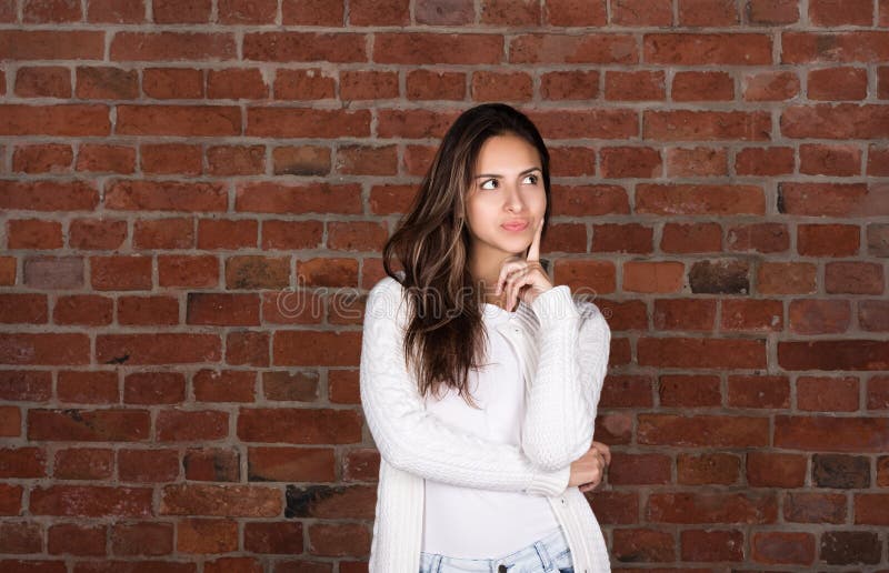Aantrekkelijke jonge vrouw in witte sweater Om over iets te denken of te kiezen royalty-vrije stock foto's Aantrekkelijke jonge vrouw in witte sweater Om over iets te denken of te kiezen royalty-vrije stock foto's