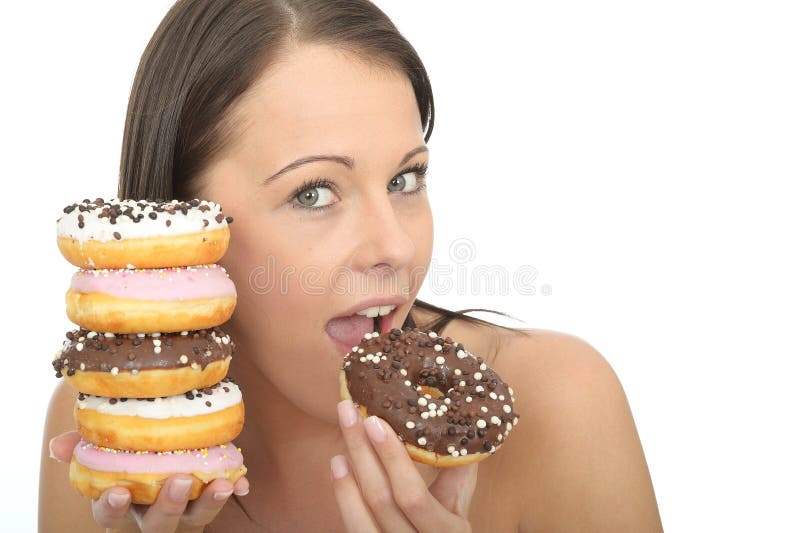 Aantrekkelijke Natuurlijke Gelukkige Jonge Vrouw die een Stapel van Bevroren Donuts eten stock foto Aantrekkelijke Natuurlijke Gelukkige Jonge Vrouw die een Stapel van Bevroren Donuts eten stock foto