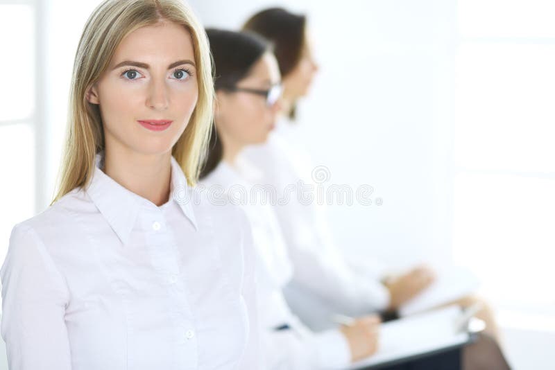 Aantrekkelijke onderneemster op vergadering of conferentie tegen de achtergrond van collega's Groep bedrijfsmensen op het werk royalty-vrije stock fotografie Aantrekkelijke onderneemster op vergadering of conferentie tegen de achtergrond van collega's Groep bedrijfsmensen op het werk royalty-vrije stock fotografie