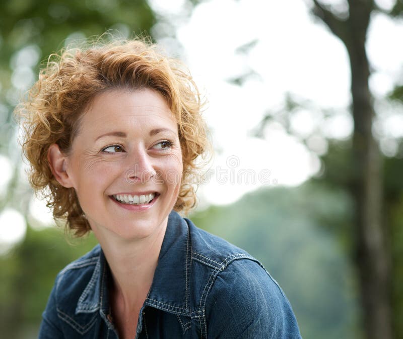 Aantrekkelijke oudere en vrouw die weg glimlachen kijken stock afbeelding Aantrekkelijke oudere en vrouw die weg glimlachen kijken stock afbeelding