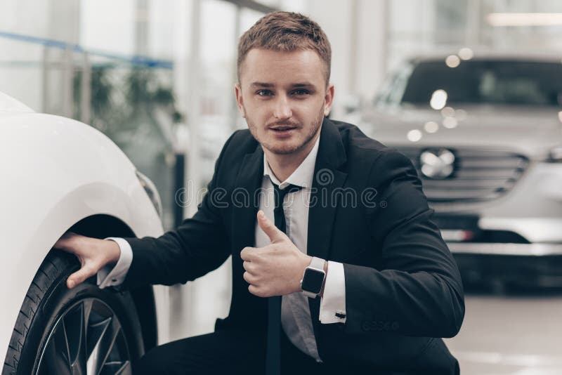 Aantrekkelijke zakenman die nieuwe auto kopen bij het handel drijven stock afbeelding Aantrekkelijke zakenman die nieuwe auto kopen bij het handel drijven stock afbeelding