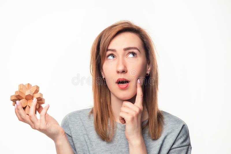 Aantrekkelijke 24 éénjarigen bedrijfsvrouw kijken die die met houten raadsel wordt verward stock afbeelding Aantrekkelijke 24 éénjarigen bedrijfsvrouw kijken die die met houten raadsel wordt verward stock afbeelding