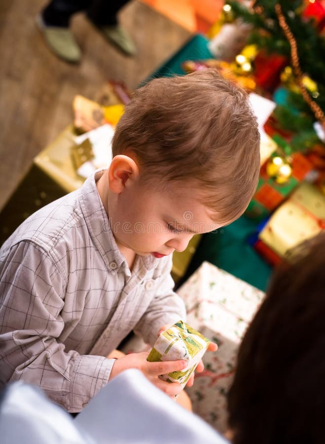 Little boy ( 3 years ) getting present at Christmas Eve. Little boy ( 3 years ) getting present at Christmas Eve.