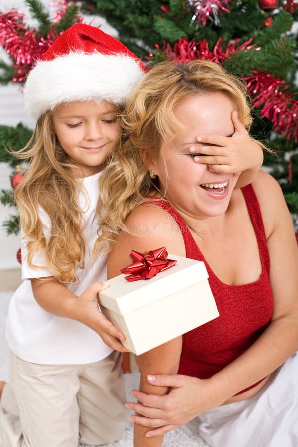 Surprise christmas present - little girl and woman in front of the decorated tree. Surprise christmas present - little girl and woman in front of the decorated tree