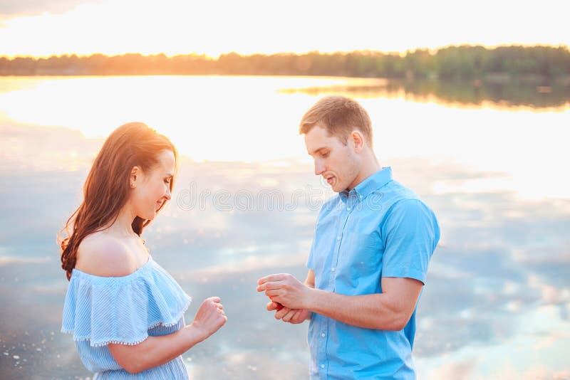 Marriage proposal on sunset . young men makes a proposal of betrothal to his girlfriend on the beach .Wedding concept. Marriage proposal on sunset . young men makes a proposal of betrothal to his girlfriend on the beach .Wedding concept