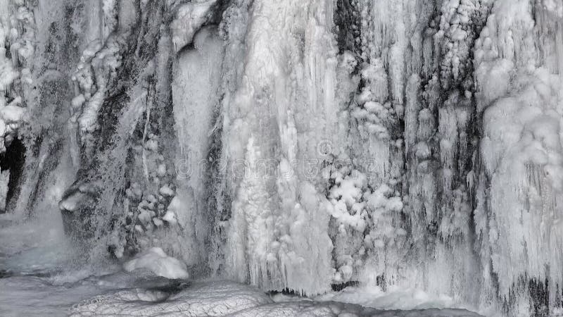 Aard. ijsland. noordpoolgebied. waterval en ijs. prachtige majestueuze winterwaterval met sneeuw en ijs. bevroren winter