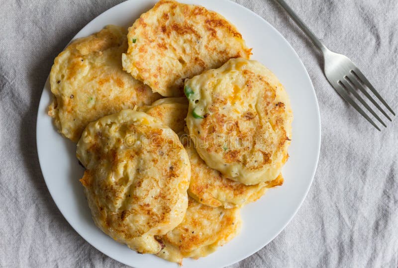Aardappelcakes op witte plaat met het dienen van vork worden opgehoopt die stock foto Aardappelcakes op witte plaat met het dienen van vork worden opgehoopt die stock foto