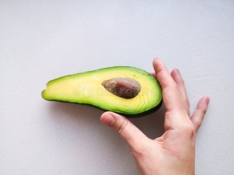 Abacate à disposição, no fundo branco Homem que propõe à mulher com acoplamento Ring In Avocado closeup Corte o abacate fotografia de stock Abacate à disposição, no fundo branco Homem que propõe à mulher com acoplamento Ring In Avocado closeup Corte o abacate fotografia de stock