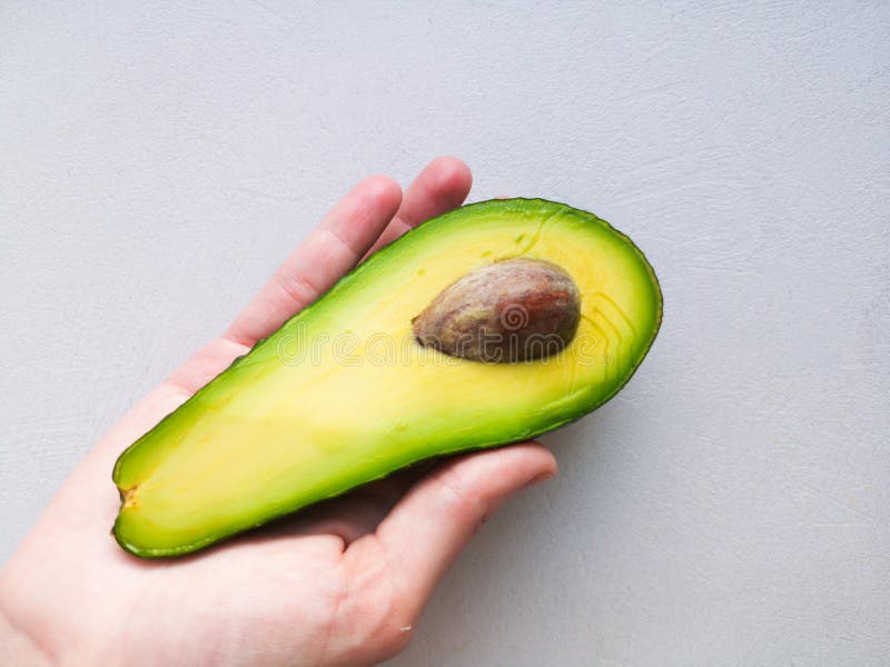 Abacate à disposição, no fundo branco Homem que propõe à mulher com acoplamento Ring In Avocado closeup Corte o abacate imagem de stock royalty free Abacate à disposição, no fundo branco Homem que propõe à mulher com acoplamento Ring In Avocado closeup Corte o abacate imagem de stock royalty free