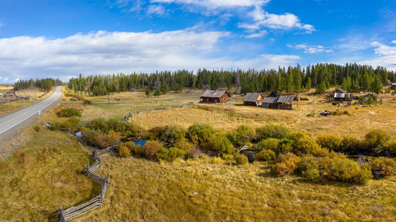 Abandoned and decayed old wooden barn, farm facilities and buildings against a stormy sky in Central Interior of British Columbia