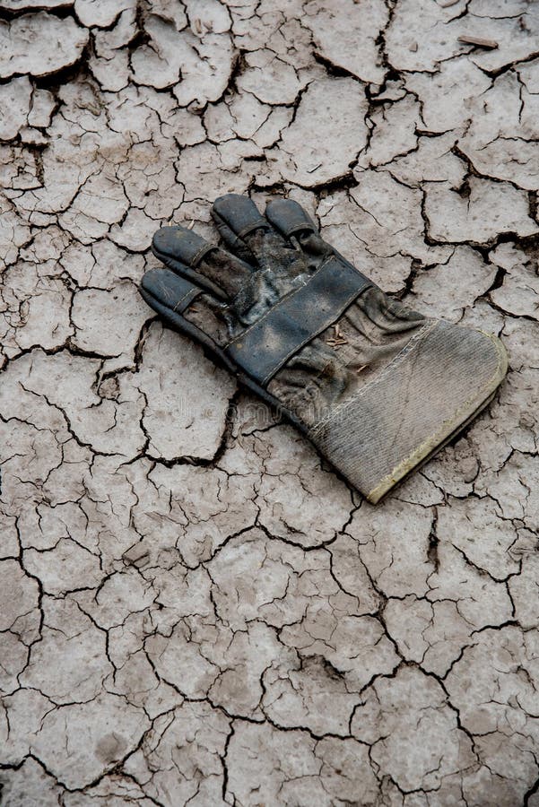 A pair of abandoned old gloves on dry mud background. Pair working gloves stock images, royalty-free photos and pictures