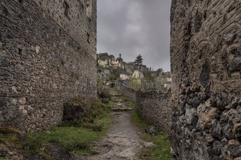 Street in Abandoned Greek Village Kayakoy in Turkey ander gloomy sky
