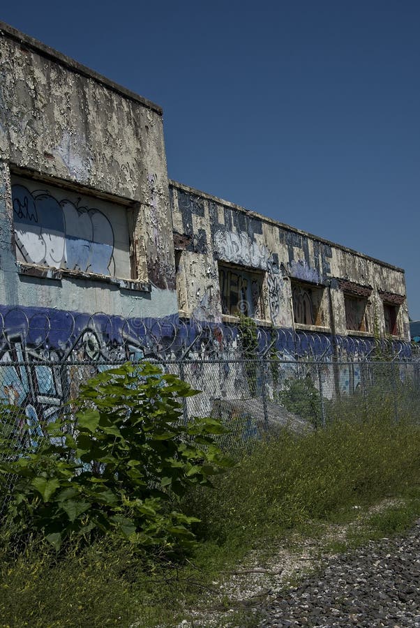 Abandoned Industrial Building with Graffiti and Barbed Wire Coils Vertical royalty free stock image Abandoned Industrial Building with Graffiti and Barbed Wire Coils Vertical royalty free stock image