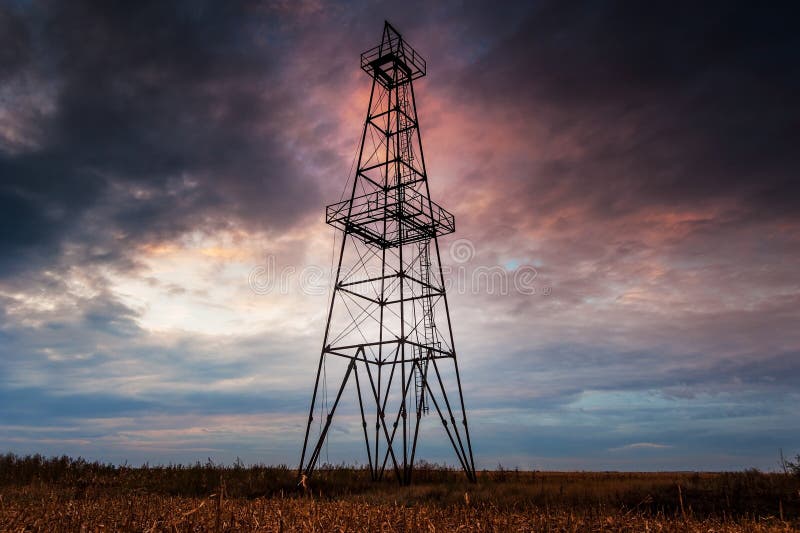 Abandoned oil rig, dramatic clouds and evening sky