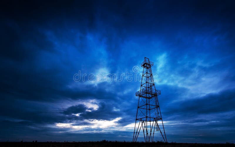 Abandoned oil rig, dramatic clouds and evening sky