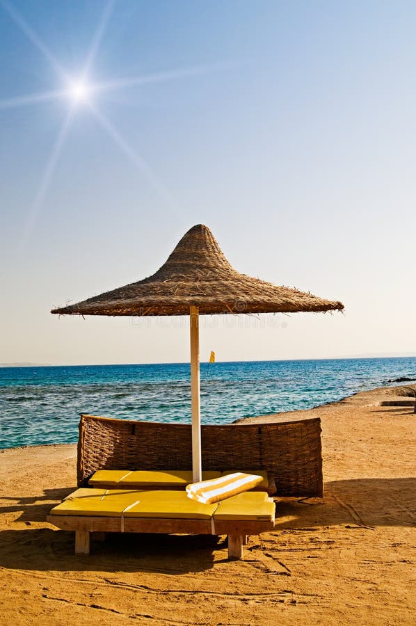 Abandoned parasol and yellow towel on the resort.