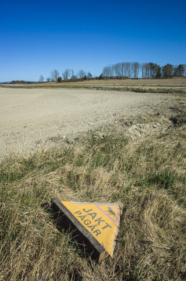 Abandoned warning sign for moose hunting next to the field in countryside near Vasteras, Sweden triangle