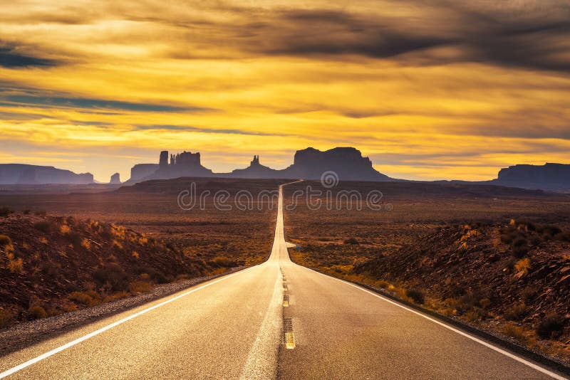Abbandoni la strada che conduce alla valle del monumento al tramonto fotografie stock Abbandoni la strada che conduce alla valle del monumento al tramonto fotografie stock