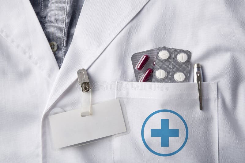 Abbigli medico con le pillole e lo spazio in bianco dell'etichetta di identificazione fotografia stock libera da diritti Abbigli medico con le pillole e lo spazio in bianco dell'etichetta di identificazione fotografia stock libera da diritti