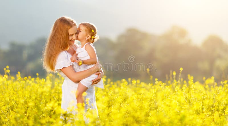 Abbraccio felice della figlia della madre e del bambino della famiglia sulla natura in somma