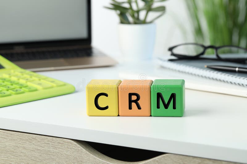 Abbreviation CRM of Cubes with Laptop on White Office Table. Customer