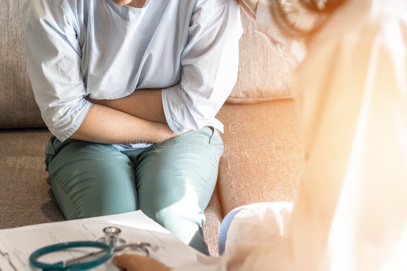 Abdominal pain patient woman having medical exam with doctor on illness from stomach cancer, irritable bowel syndrome