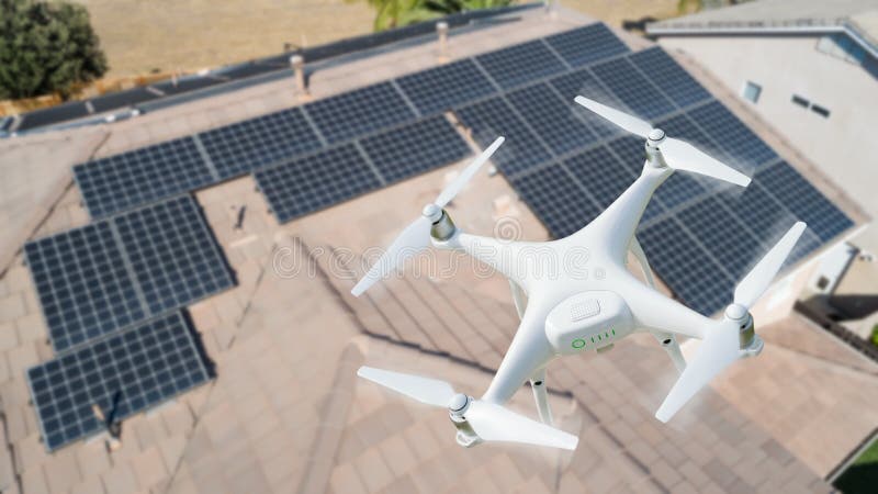 Abejón del UAV que examina los paneles solares en tejado casero grande foto de archivo Abejón del UAV que examina los paneles solares en tejado casero grande foto de archivo