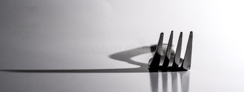 Abendessen-Gabel wirft gro?en Schatten lizenzfreies stockbild Abendessen-Gabel wirft gro?en Schatten lizenzfreies stockbild