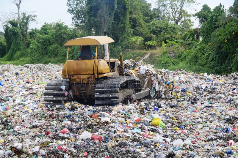 Bulldozer spreads garbage in a landfill; rural area. Bulldozer spreads garbage in a landfill; rural area