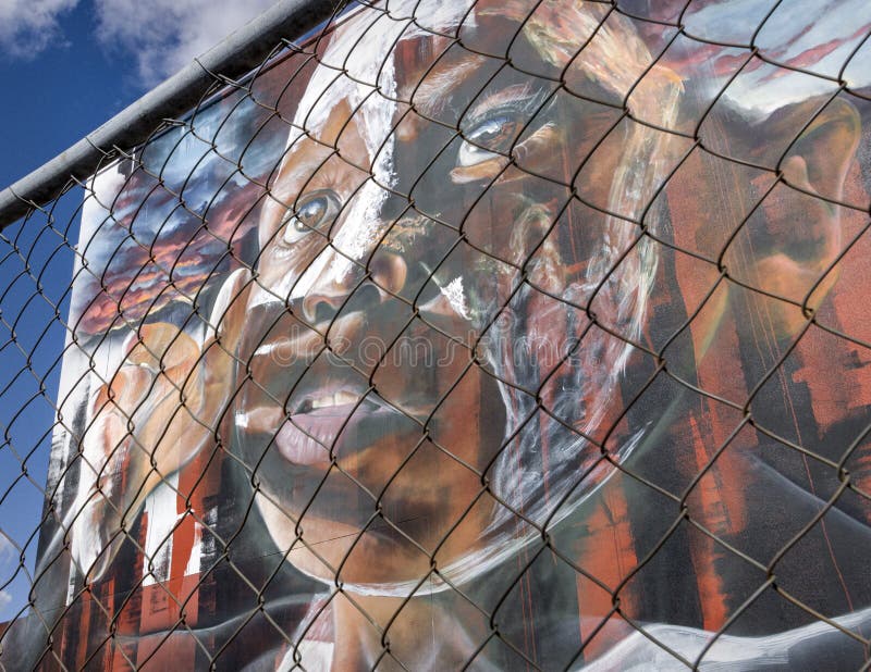 Aboriginal Mural on a Wall in Toowoomba, Queensland, Australia. I took this image looking through a fence to convey the way of life & culture of the Aboriginal people that has been suppressed. Aboriginal Mural on a Wall in Toowoomba, Queensland, Australia. I took this image looking through a fence to convey the way of life & culture of the Aboriginal people that has been suppressed.