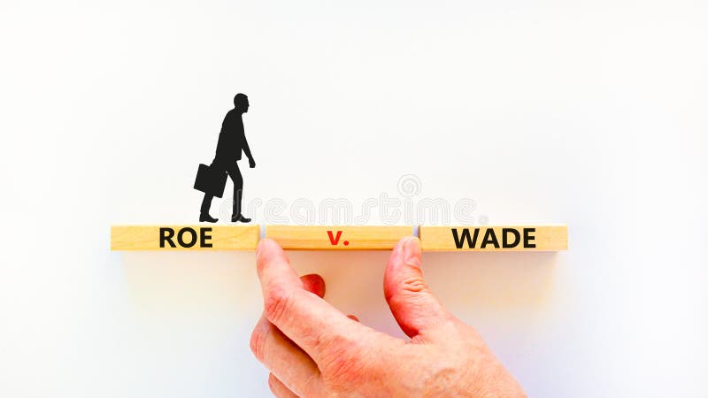 Abortion process Roe versus Wade symbol. Concept words Roe versus Wade on wooden blocks. Lawyer hand. Beautiful white table white