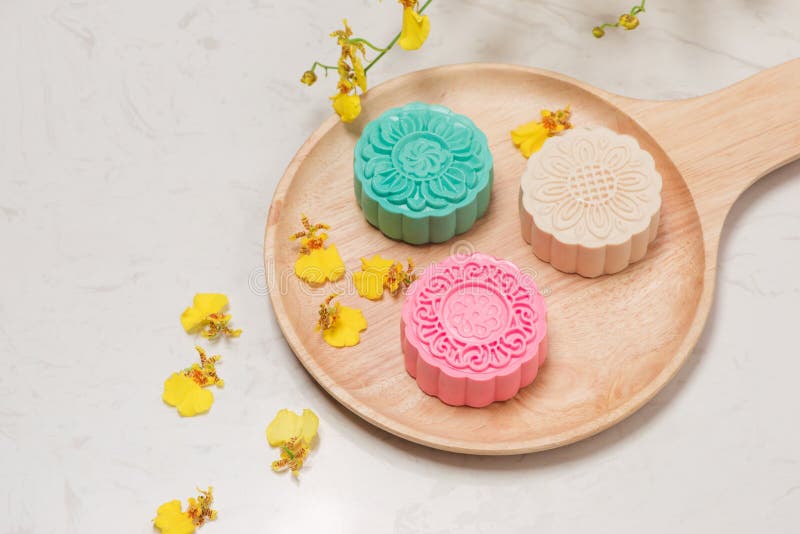 Above of colorful mooncake on dish with tea cup on background.