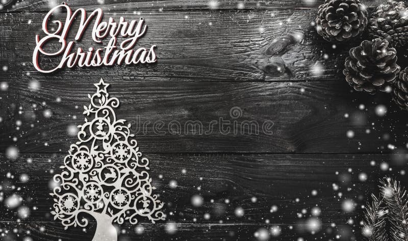 Above view of handmade evergreen tree toy, golden pines and Merry Christmas inscription on black wooden background stock photography Above view of handmade evergreen tree toy, golden pines and Merry Christmas inscription on black wooden background stock photography