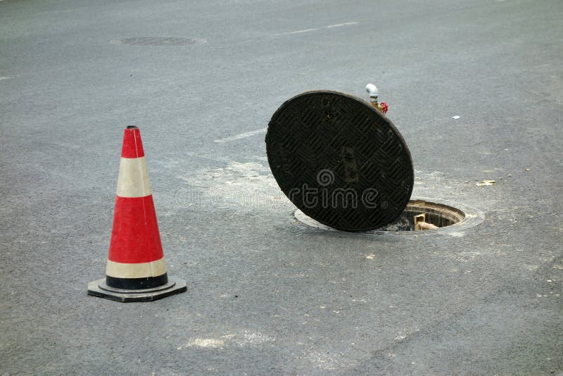 Open manhole of sewer and warning tubes. Open manhole of sewer and warning tubes.