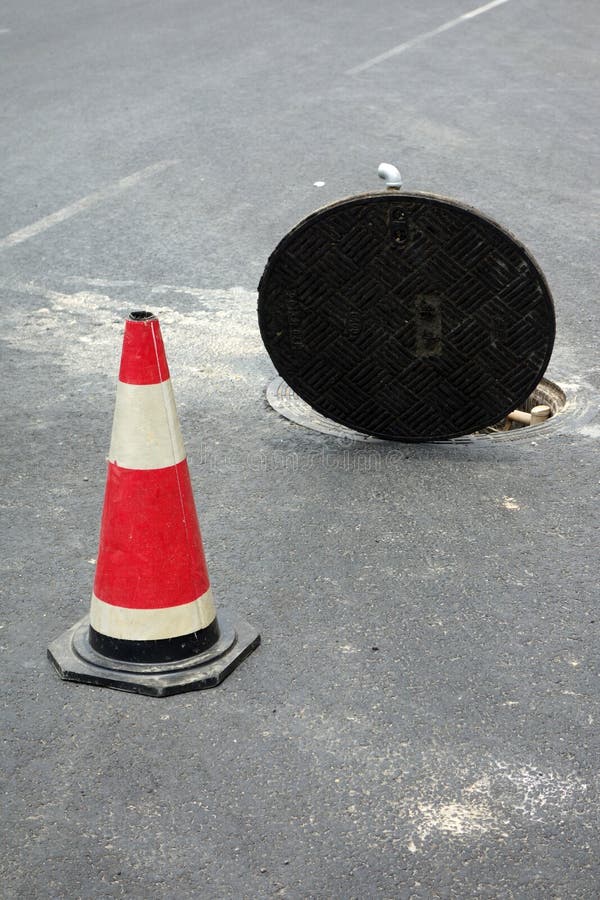 Open manhole of sewer and warning tubes. Open manhole of sewer and warning tubes.