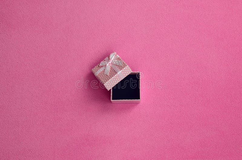 Abra la pequeña caja de regalo en rosa con mentiras pequeñas de un arco en una manta de la tela rosa clara suave y peluda del pañ imágenes de archivo libres de regalías Abra la pequeña caja de regalo en rosa con mentiras pequeñas de un arco en una manta de la tela rosa clara suave y peluda del pañ imágenes de archivo libres de regalías