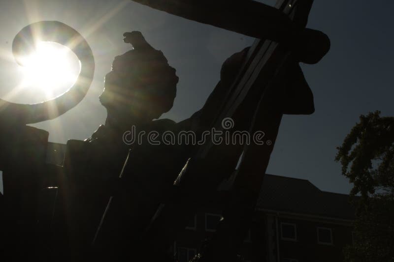 Abraham Lincoln statue silhouette with sun. Abraham Lincoln statue silhouette sitting on bench with sun in background stock images Abraham Lincoln statue silhouette with sun. Abraham Lincoln statue silhouette sitting on bench with sun in background stock images
