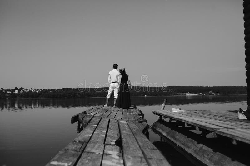 Abrazo del hombre y de la mujer en amor en el embarcadero de madera fotos de archivo Abrazo del hombre y de la mujer en amor en el embarcadero de madera fotos de archivo
