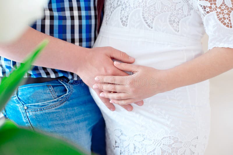 Abrazos de la oferta del marido del primer del vientre embarazada imagen de archivo Abrazos de la oferta del marido del primer del vientre embarazada imagen de archivo