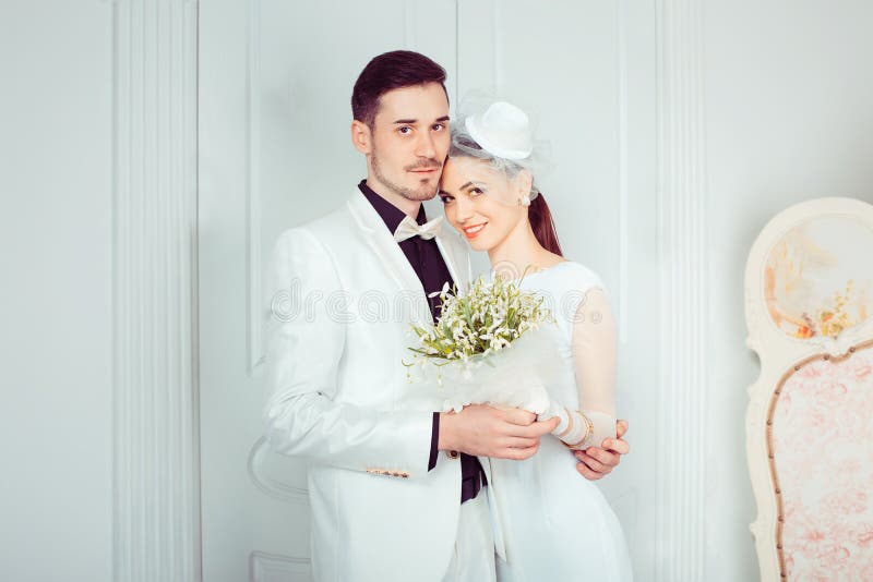 Abraçando recém-casados bonitos no interior elegante fotografia de stock Abraçando recém-casados bonitos no interior elegante fotografia de stock
