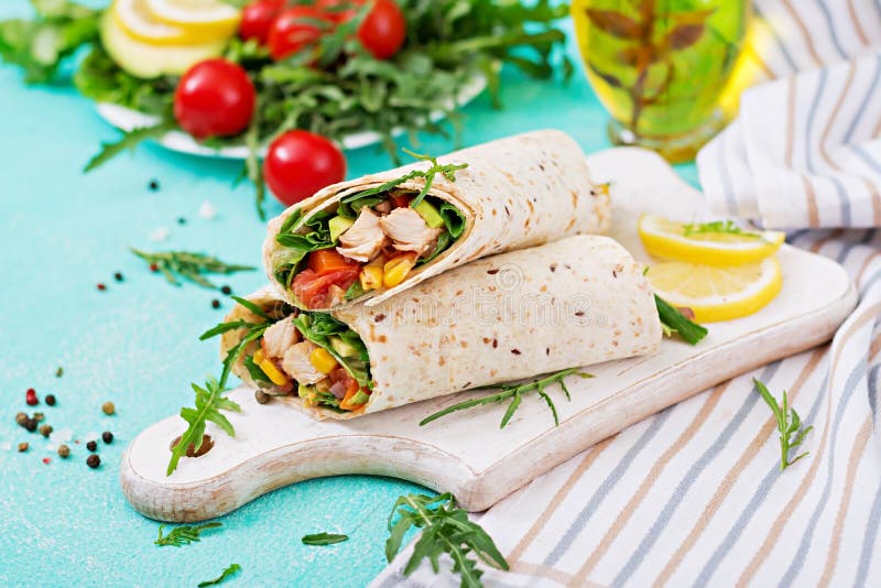 Abrigos de los Burritos con el pollo y las verduras en fondo ligero foto de archivo libre de regalías Abrigos de los Burritos con el pollo y las verduras en fondo ligero foto de archivo libre de regalías